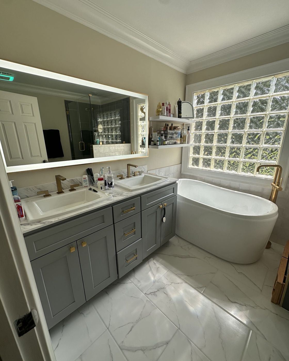 A finished bathroom vanity with gold fixtures next to a freestanding tub