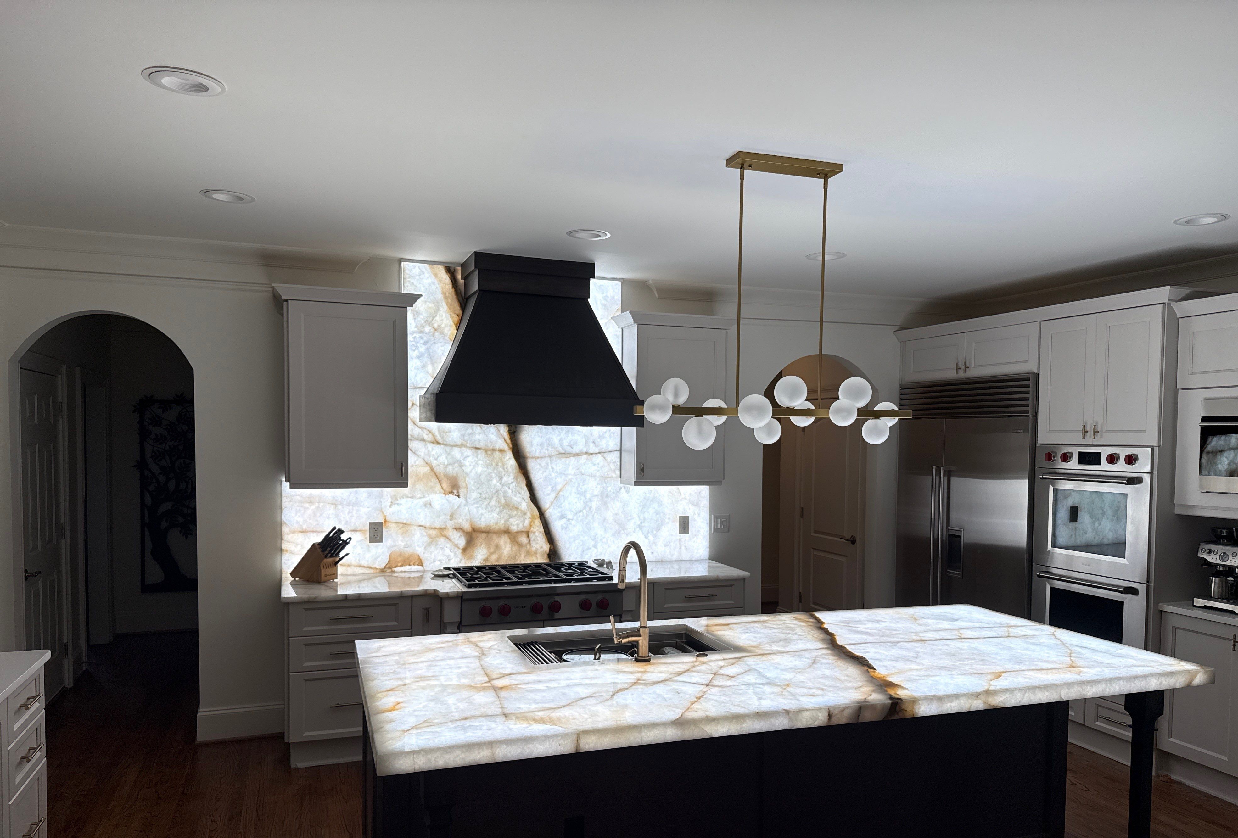 Luxury kitchen remodel with black range hood and marble waterfall island, North Atlanta